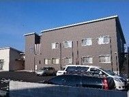 どっしりとした建物は落ち着いた色合いを採用。建物周辺には駐車場があり、高い建物はない。