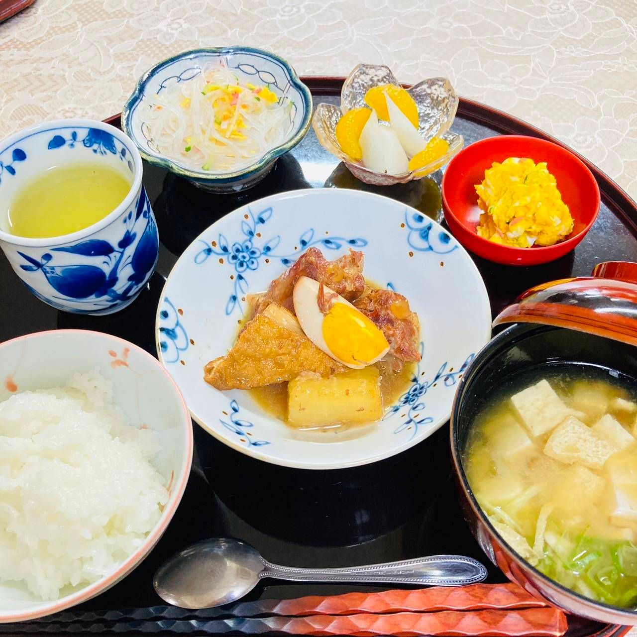 お盆にセットされた3品のおかずとご飯、お味噌汁とデザート