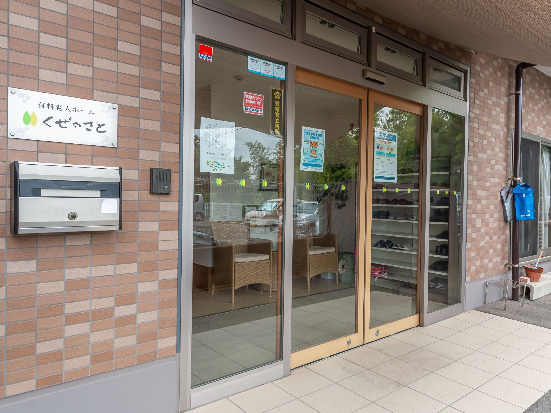 なにかを見ながら談笑しているスタッフと高齢者の様子。施設内の会話の場面