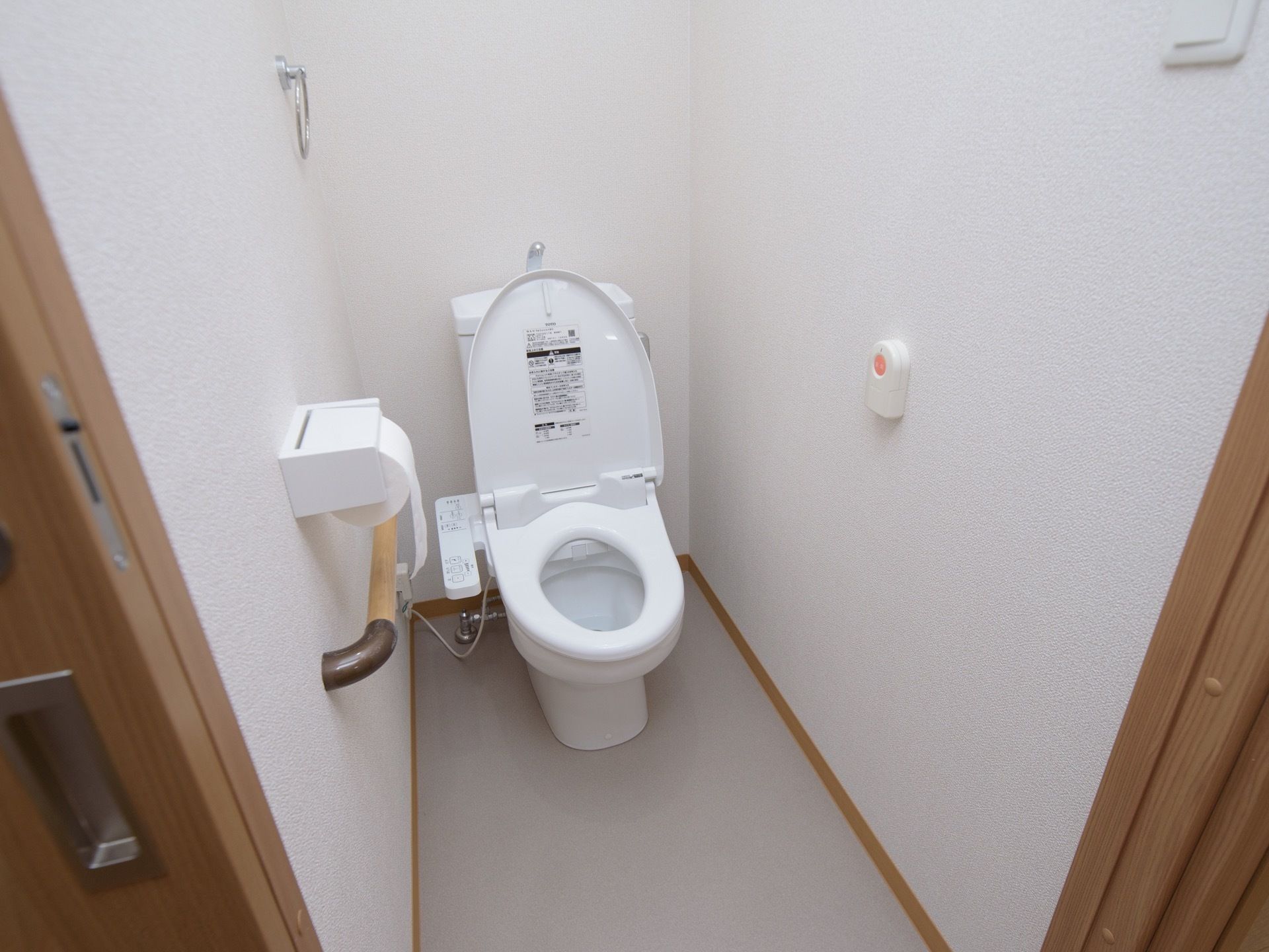 トイレには、洗浄機能付き温水便座がある。壁面には、手すりと緊急時のナースコールボタンが備えられている。