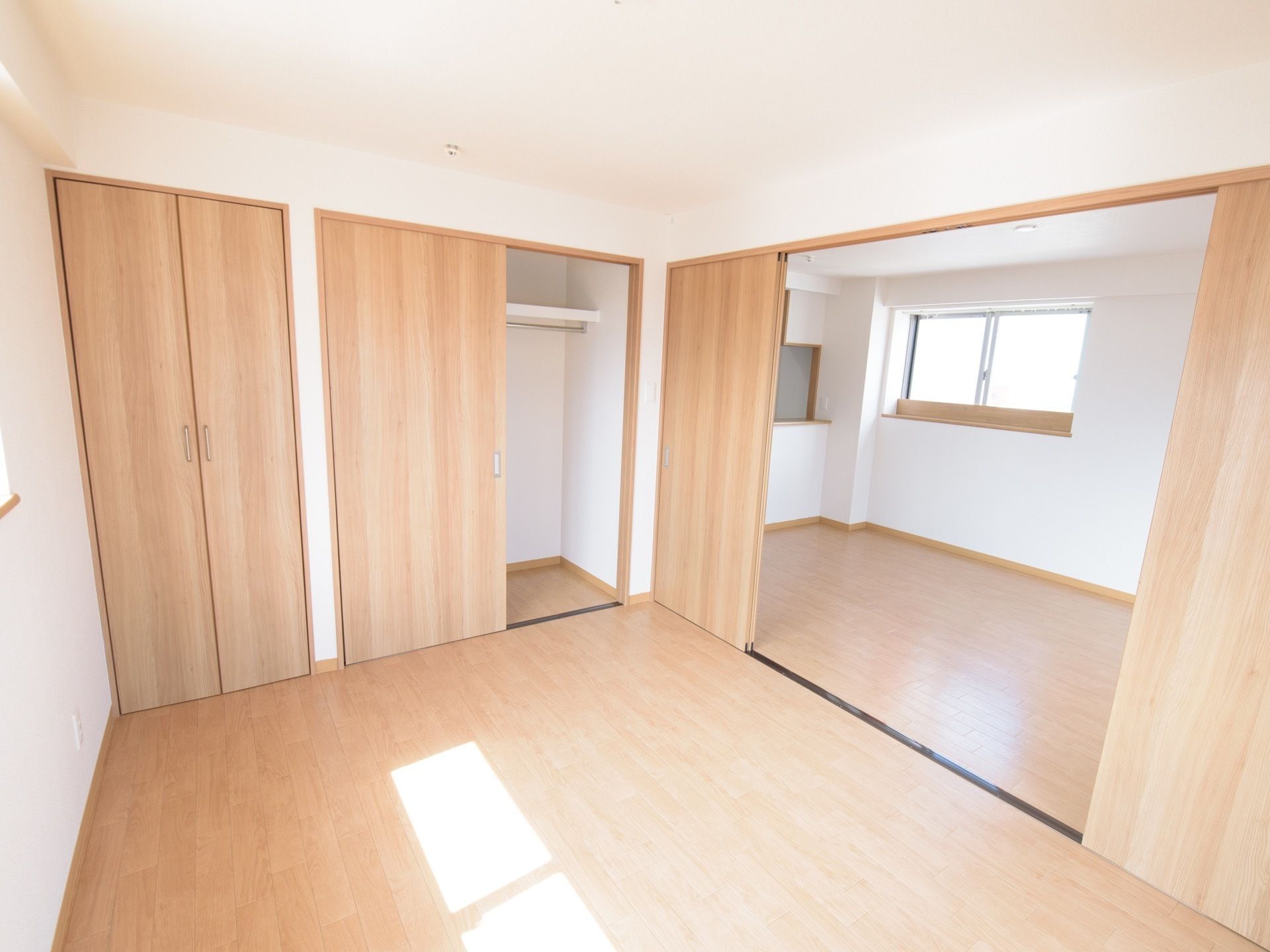 居室は、扉と床が白木の木目調で統一されている。部屋には２枚扉の開き戸と並んで引き戸の収納庫がある。居住空間は扉で仕切られ２部屋になっている。