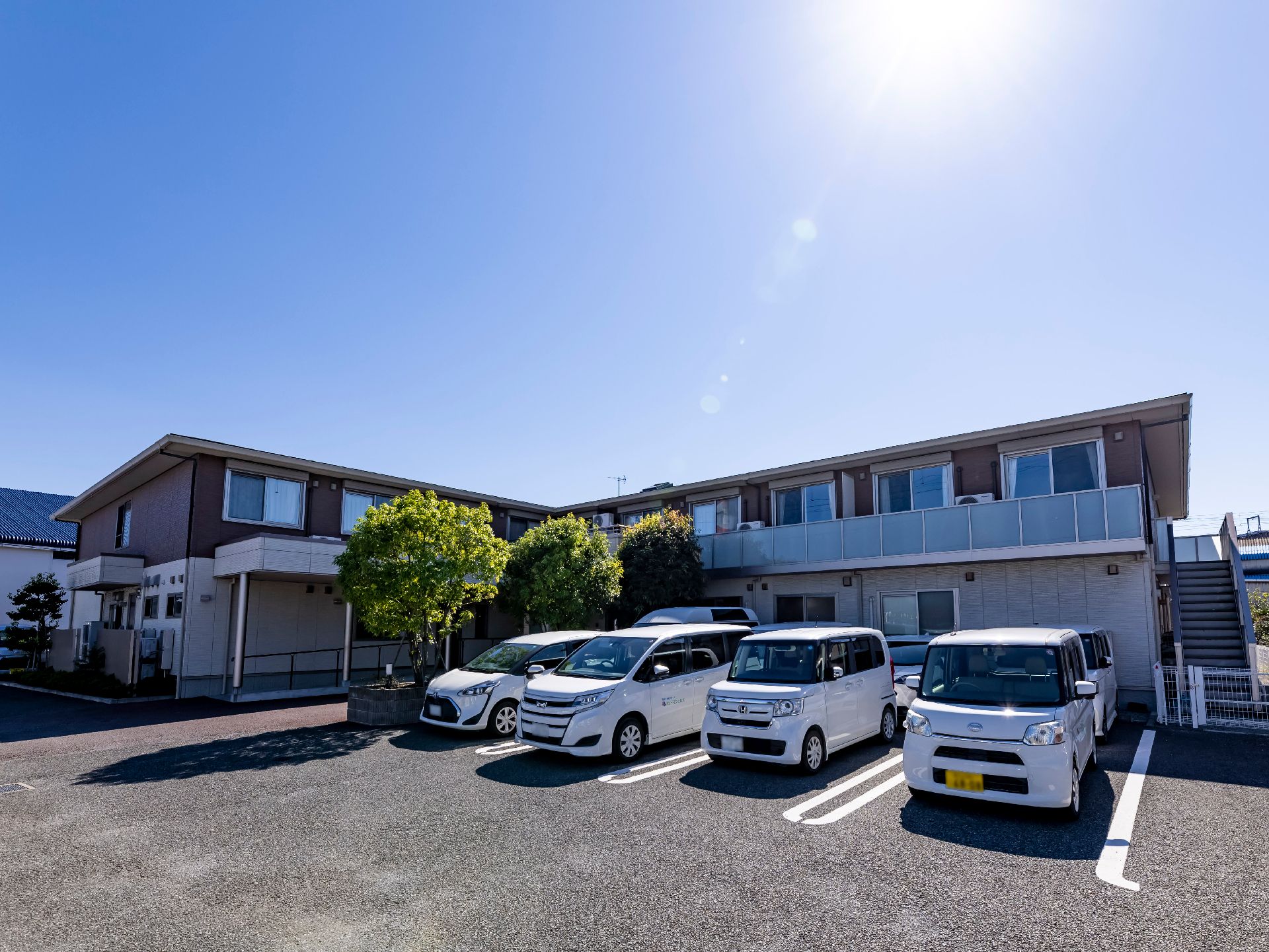 駐車場から撮影した２階建ての介護施設の外観