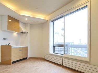 大きな窓が付いたオール電化のキッチン付きの居室。窓の外には町の景色が広がっている。