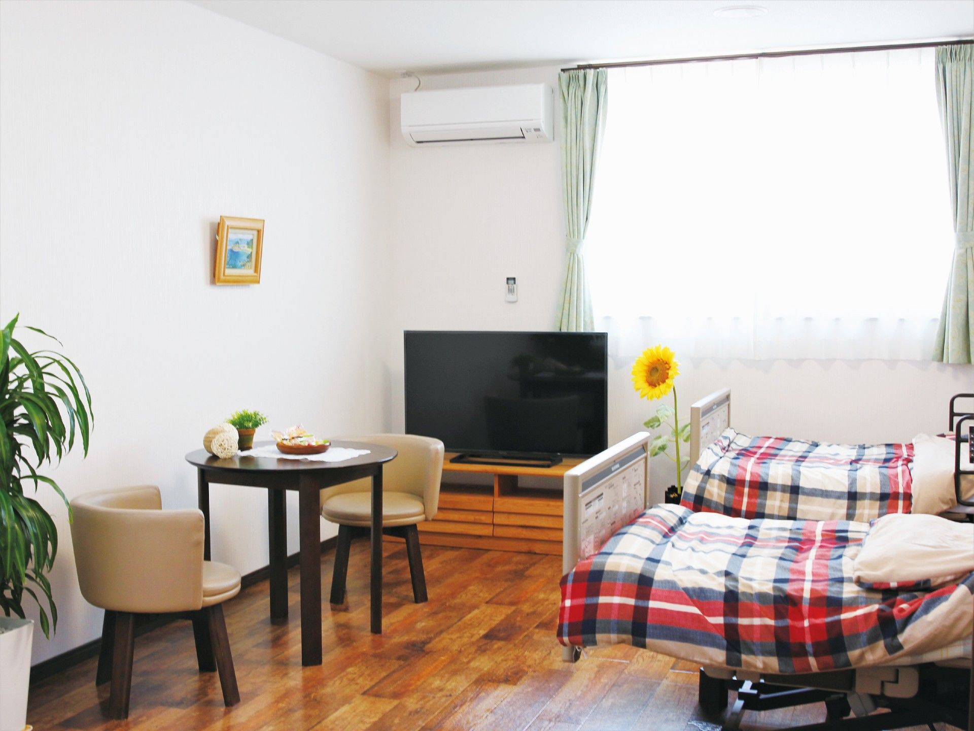 二人用の居室には介護用ベッドが二つ置かれ、大きな窓のそばにはエアコンが付いている。
