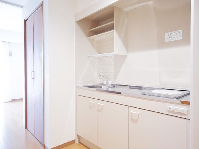 小さなキッチンスペースがある部屋の様子。火を使わないIHタイプのキッチン