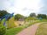 遊歩道が付いた公園にはカラフルな遊具が複数設置されている。奥には丘もある。