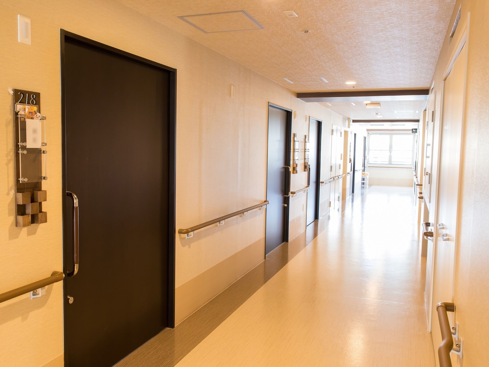廊下の突き当りには窓があり明るい。壁には手すりが備わっており安心して歩行できる。横幅にゆとりがある。