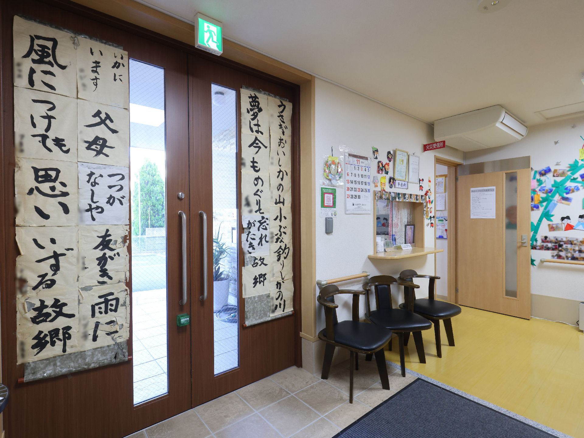 笑顔でリハビリをする高齢女性と指導する理学療法士の男性
