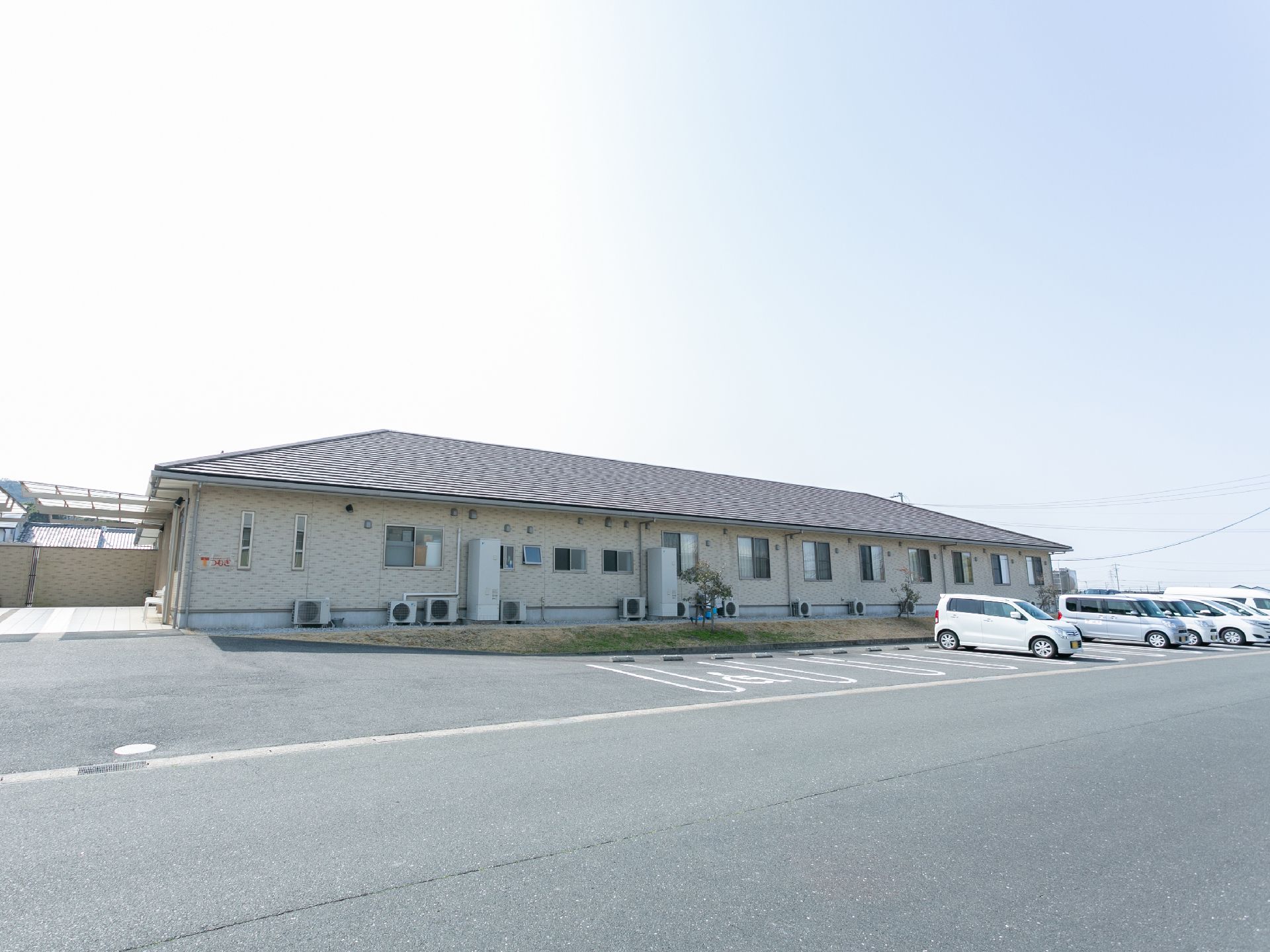 平屋建てのグループホームの建物と駐車場