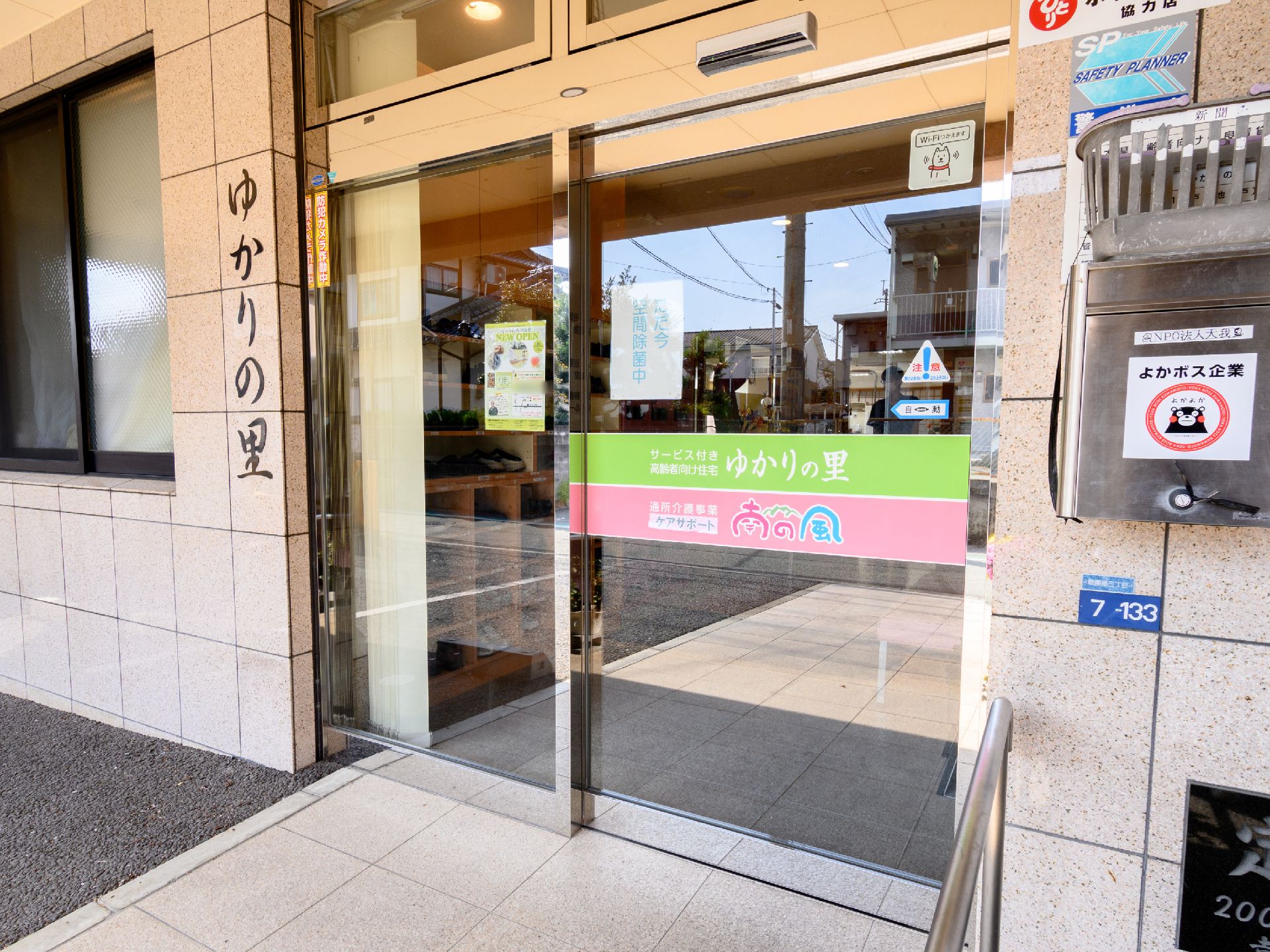 施設の名前が書かれた看板が設置された玄関