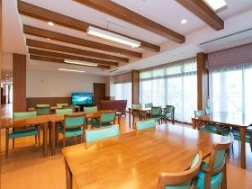 梁の見えるデザインの建物の内部。施設内の共有スペースの写真。