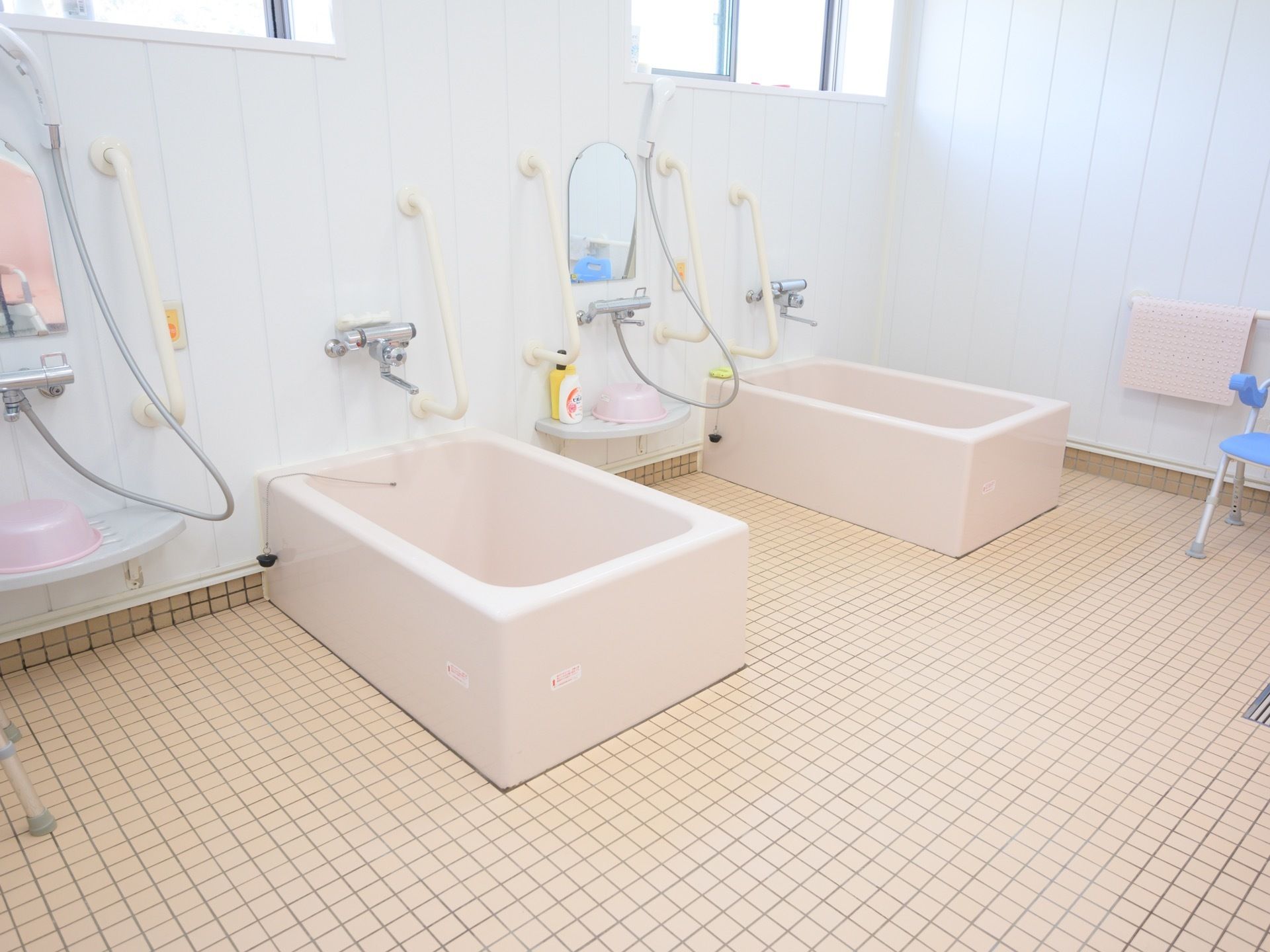 複数人が入れる大きさの浴室。１人用の浴槽が２つあり、横にそれぞれシャワーがある。窓もついている。
