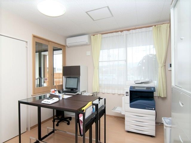 テーブルとコピー機がある施設内のスタッフルーム。常駐している部屋