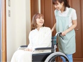 車いすから立ち上がろうとしている男性とそれを補助しようとしている女性スタッフの様子