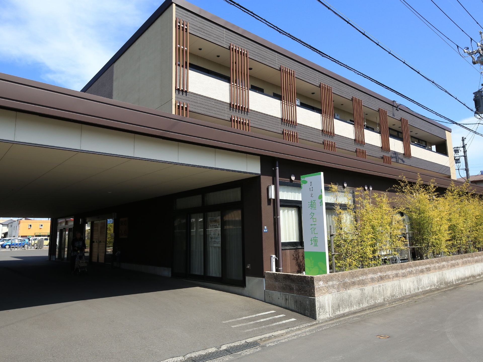 広い駐車場につながる、道路に面した二階建ての施設入口