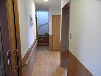 階段へと続くまっすぐな廊下。木目調の温かみのある館内。