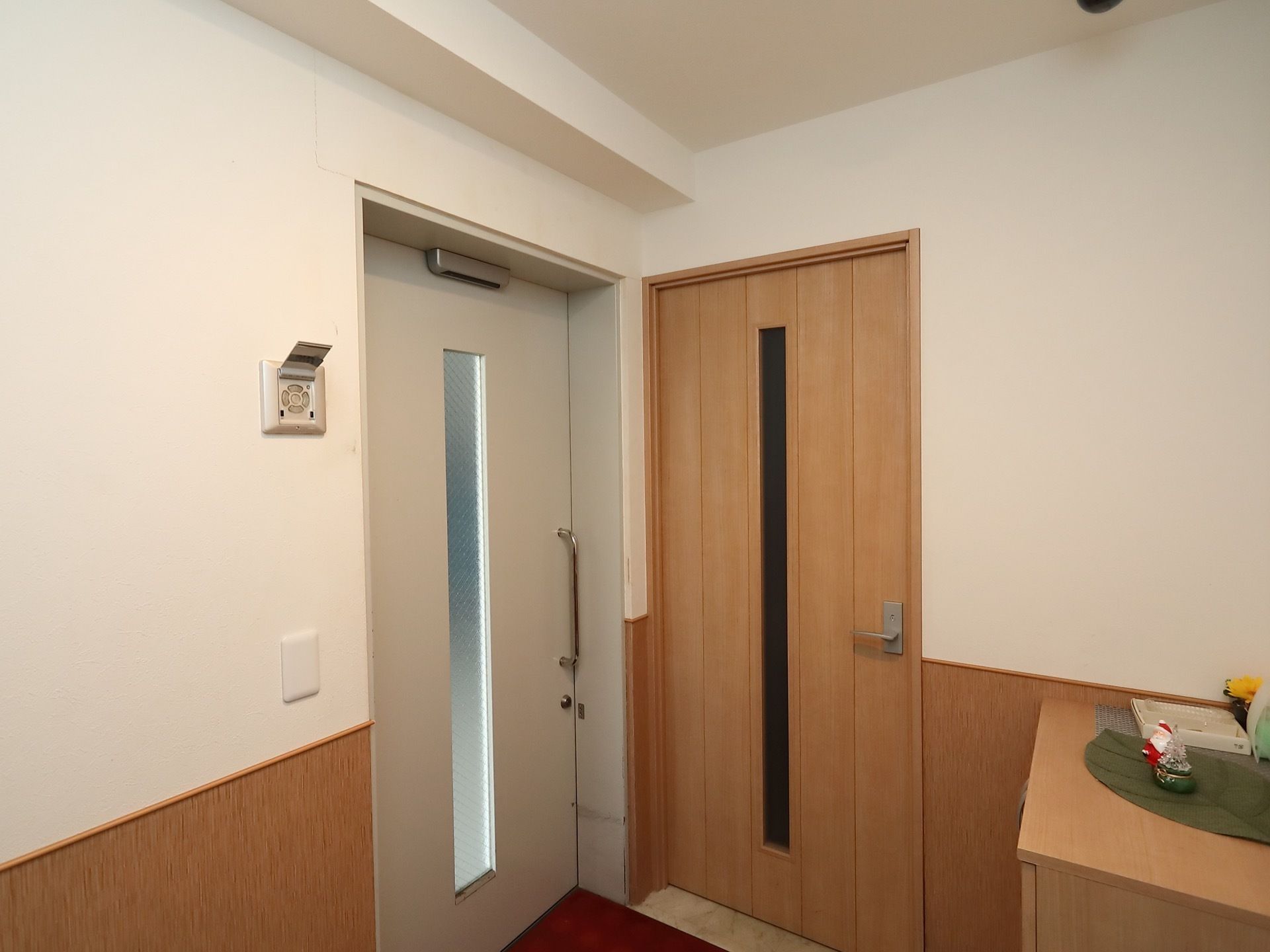 施設内の建具は、ナチュラル系の木材を多く用いているため、あたたかみのある雰囲気となっている。棚の上に、小物が置かれている。