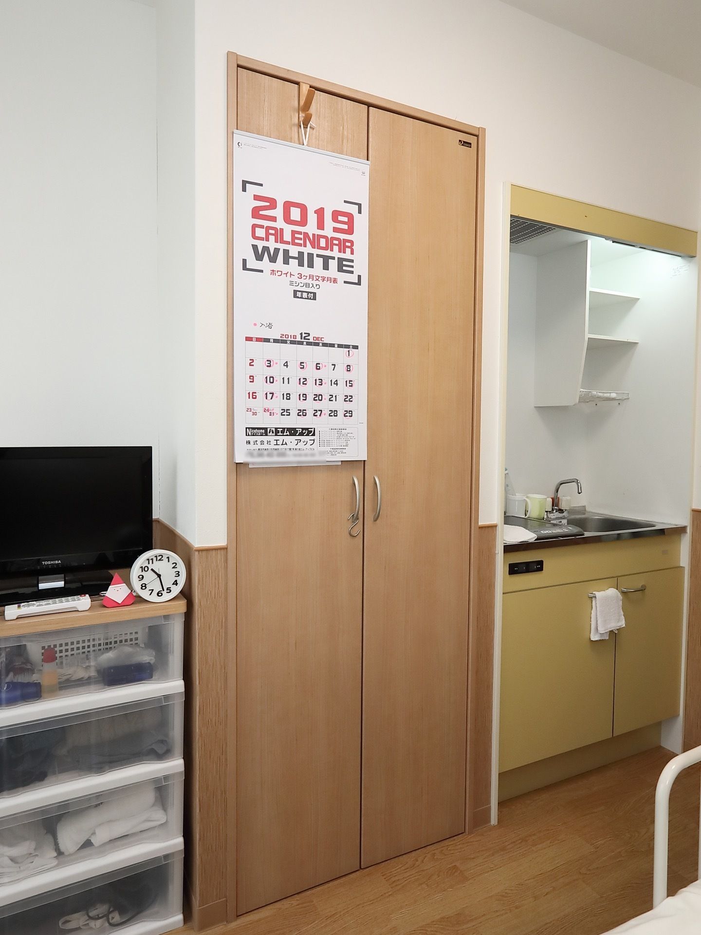 居室内にはキッチンやクローゼットなどが備えつけられている。プラスチック製の収納棚の上にはテレビが置かれている。