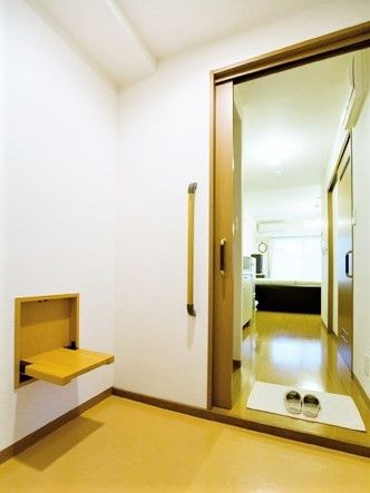 玄関には折り畳み式のベンチがあり、引き戸を開けたところにはスリッパが置かれたマットもある。