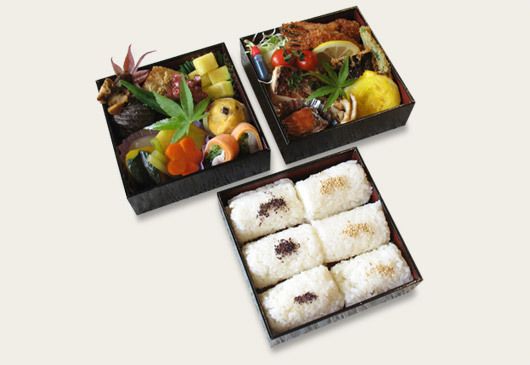 野菜の煮物や海老フライ、俵型おにぎりの入った弁当