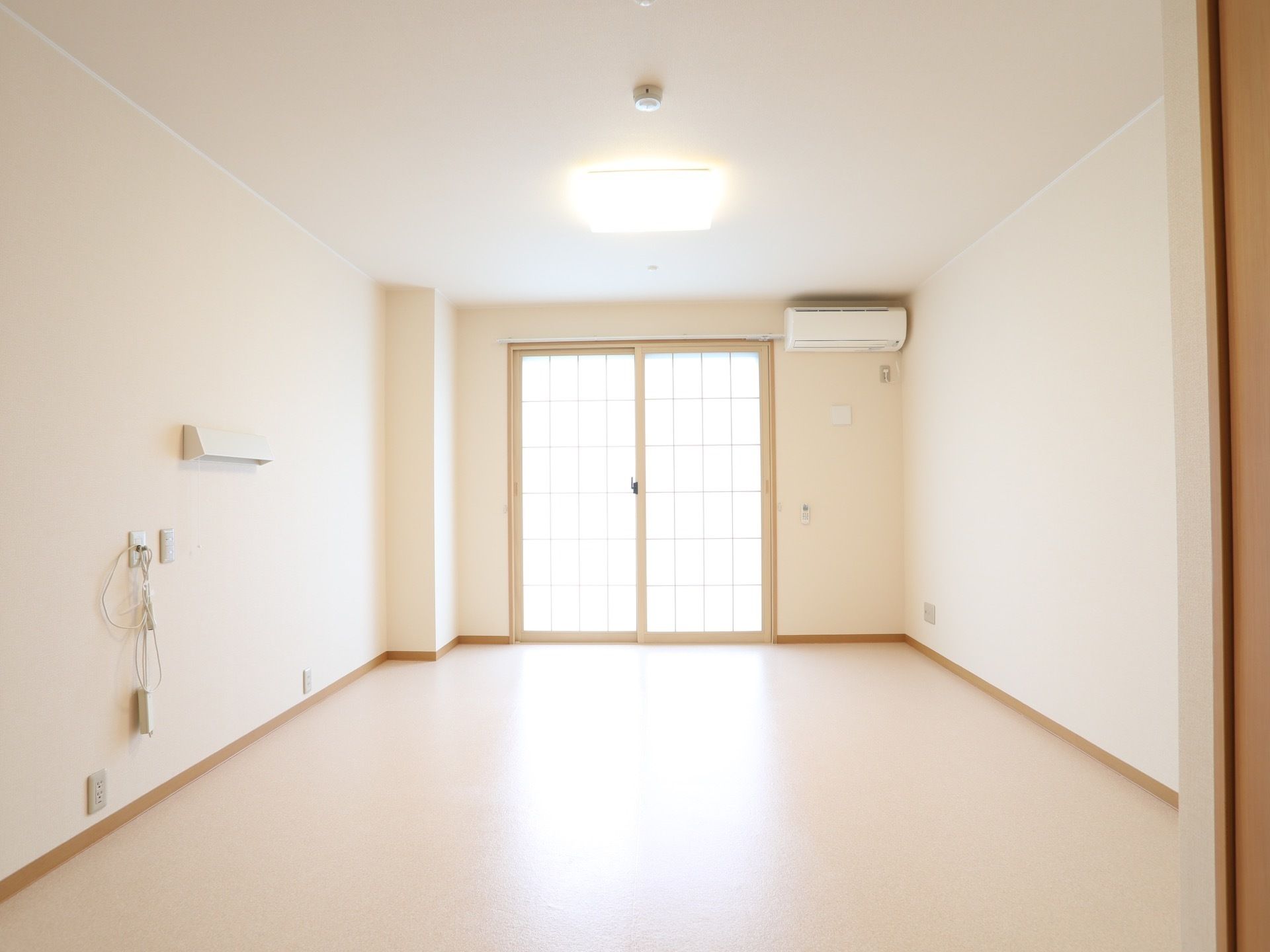 白を基調とした、奥行きのあるビニール床の居室がある。突き当たりには障子風の窓があり、やわらかい光が入っている。