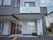 白い外観の建物にある屋根が付いた入り口