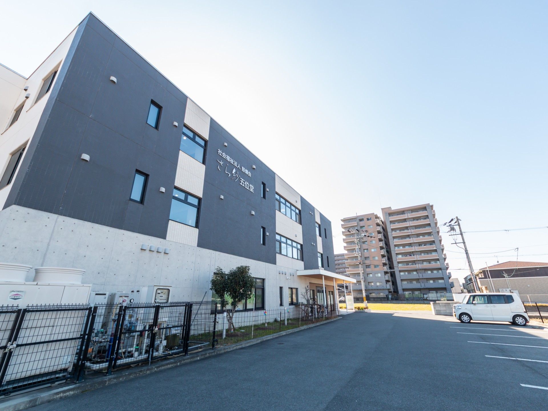 広い駐車場のある建物外観