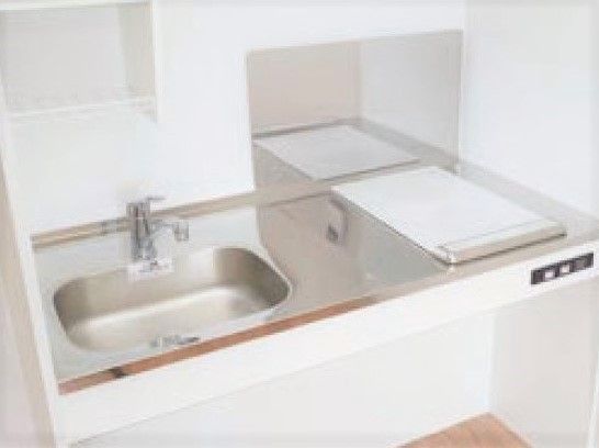 一人用の小さなキッチンスペース。電子調理器と小さな流しがある
