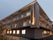 薄暗くなってきて館内には明かりが灯っている。3階建ての建物の各フロアにベランダがあり、駐車場もある。