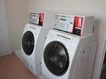 ドラム式の洗濯乾燥機が２台並んで設置されているスペース。洗濯乾燥機はコインランドリー式。
