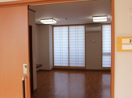 スライド式のドアが設置された広い居室内には家具や家電はなく、和風の照明や障子が設置されている。
