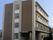 グレーとブラウンの4階建ての建物は日当たりのいい場所に建っていて、各フロアにベランダがある。