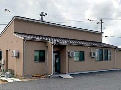 住宅型有料老人ホームや併設事業所名が書かれているライトグリーンの看板が敷地内に立っている。