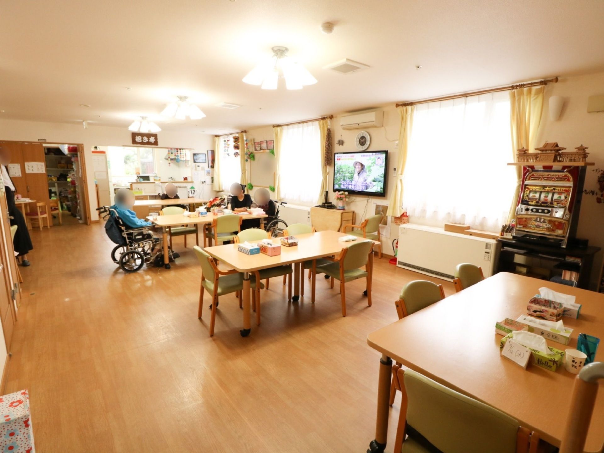 テーブルとスロットゲームのマシン、テレビが置かれた広い部屋