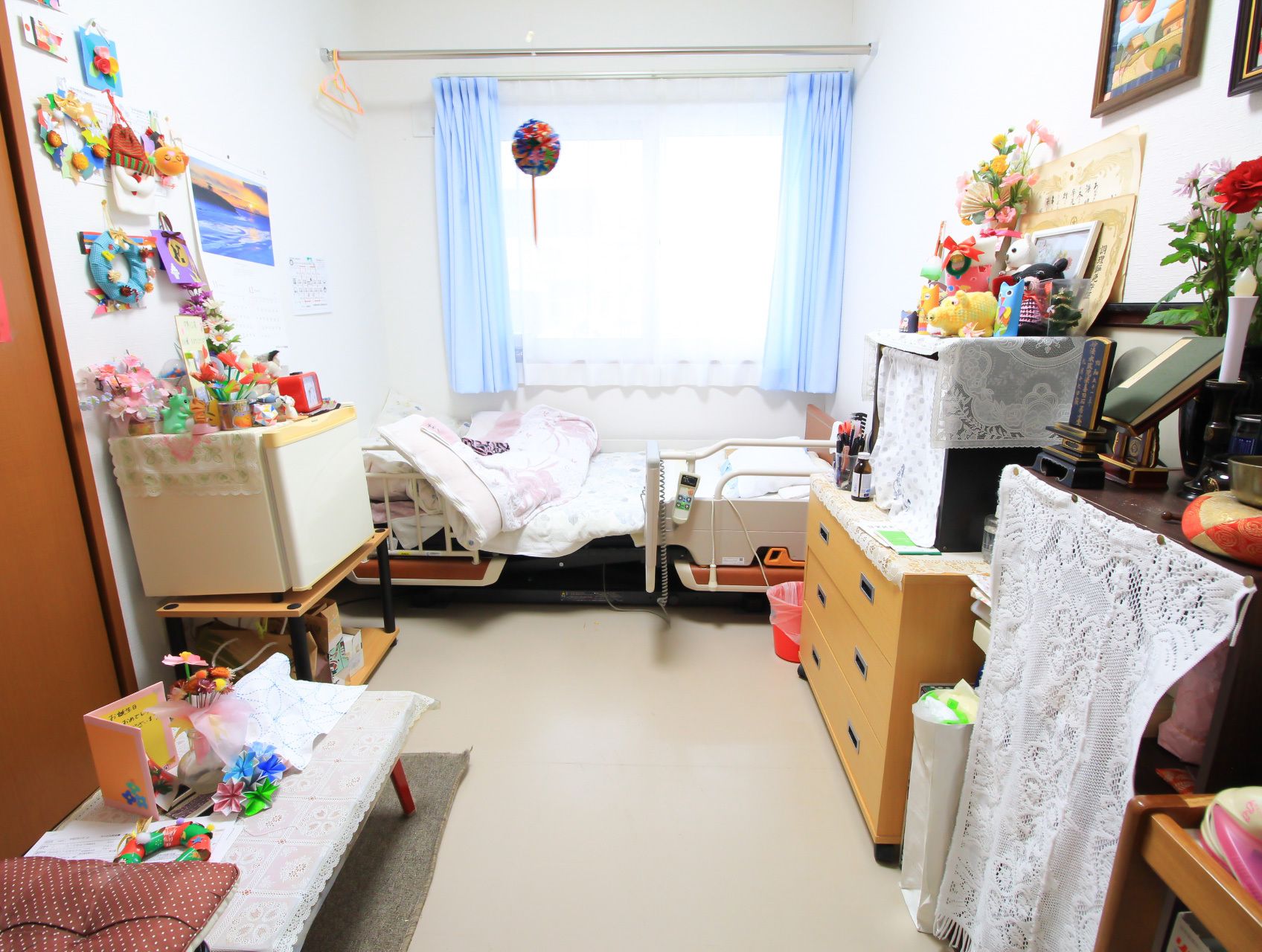置物や小物で飾られている、ベッドと収納が置かれた部屋