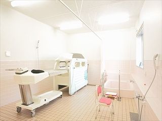 大きな浴室内に浴槽と介護式浴槽が置いてある様子。右側に窓があるスペース