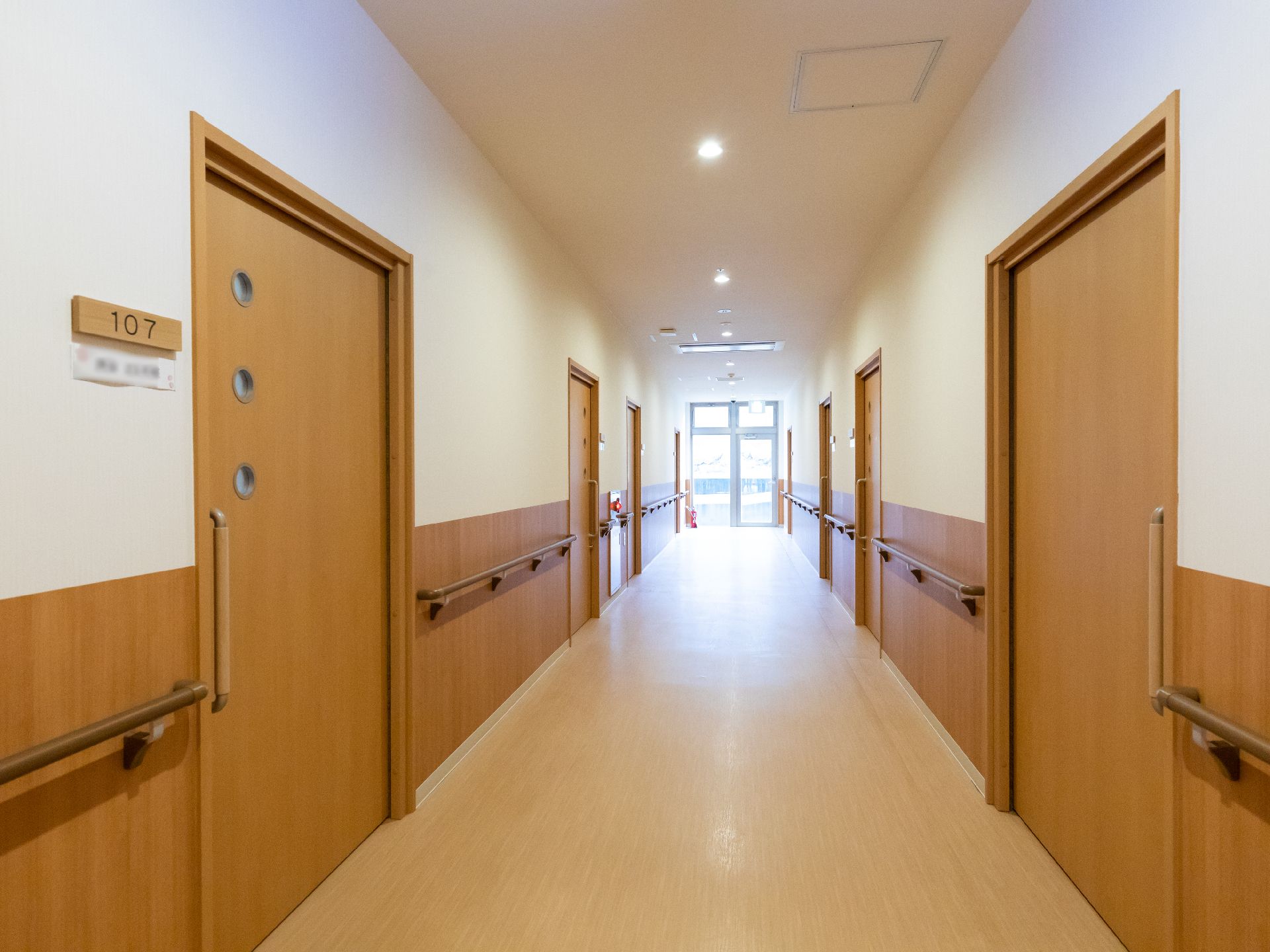 居室のドアを開けやすくするための手すりが設置されている廊下