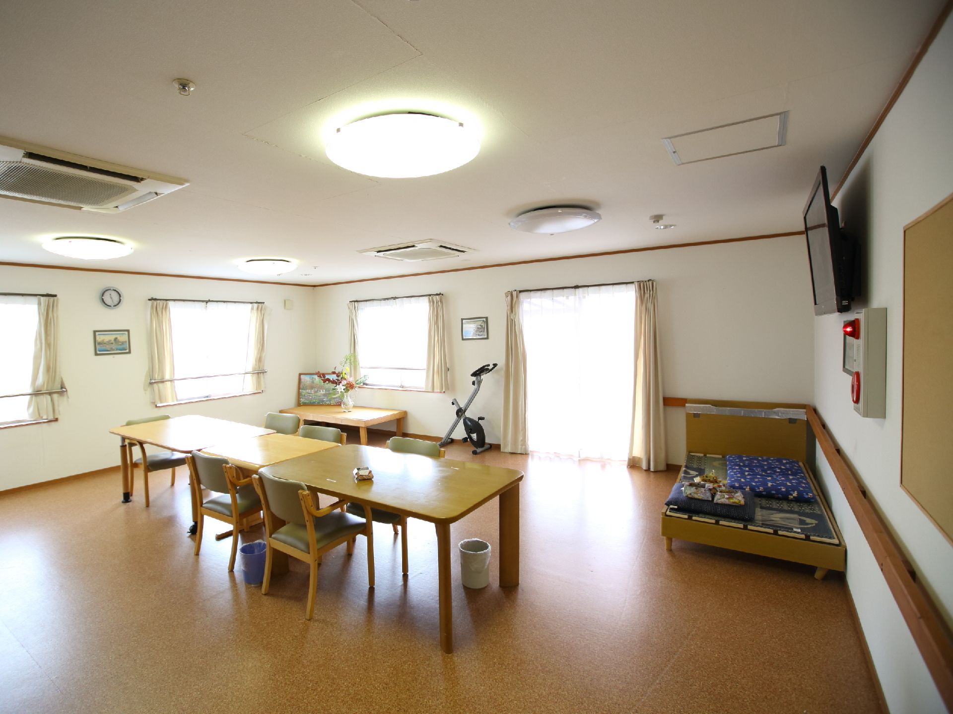 テーブルとベッド、壁掛けのテレビが置かれた広い部屋