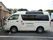 白い送迎車で、車体には施設名が大きく記されている。車両後半部がプライバシーガラスになっているため、中が見えにくい。