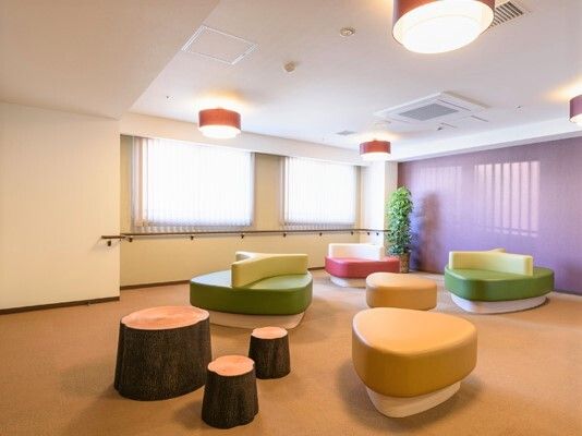 切り株のような形をしたソファ類が置かれている施設内の談話コーナー