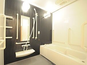 家庭によくあるサイズ感の浴室の様子。壁にまんべんなく取り付けられた手すりがある