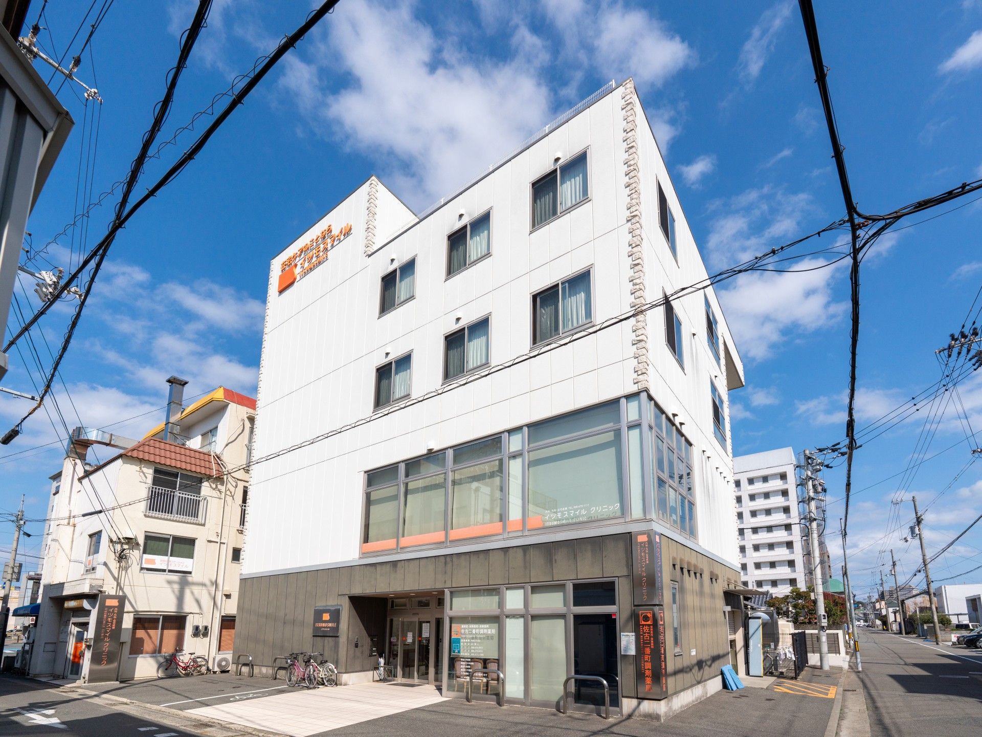 薬を飲もうとしている高齢女性のそばに水の入ったコップを持ったエプロンを付けた若い女性スタッフがいてほほ笑んでいる。