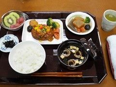 ごはんとおかずが並んでいる施設の食事例。汁物やフルーツも整っているメニュー