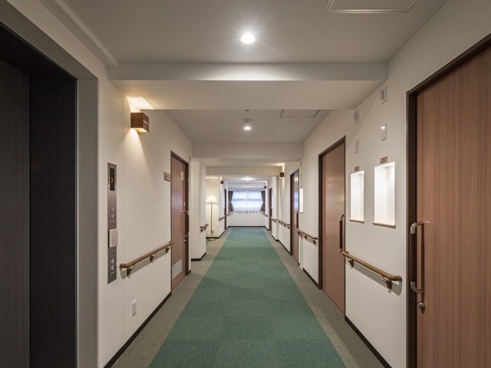 手すりが取り付けてある施設内の廊下の様子。両側に個室のドアがある