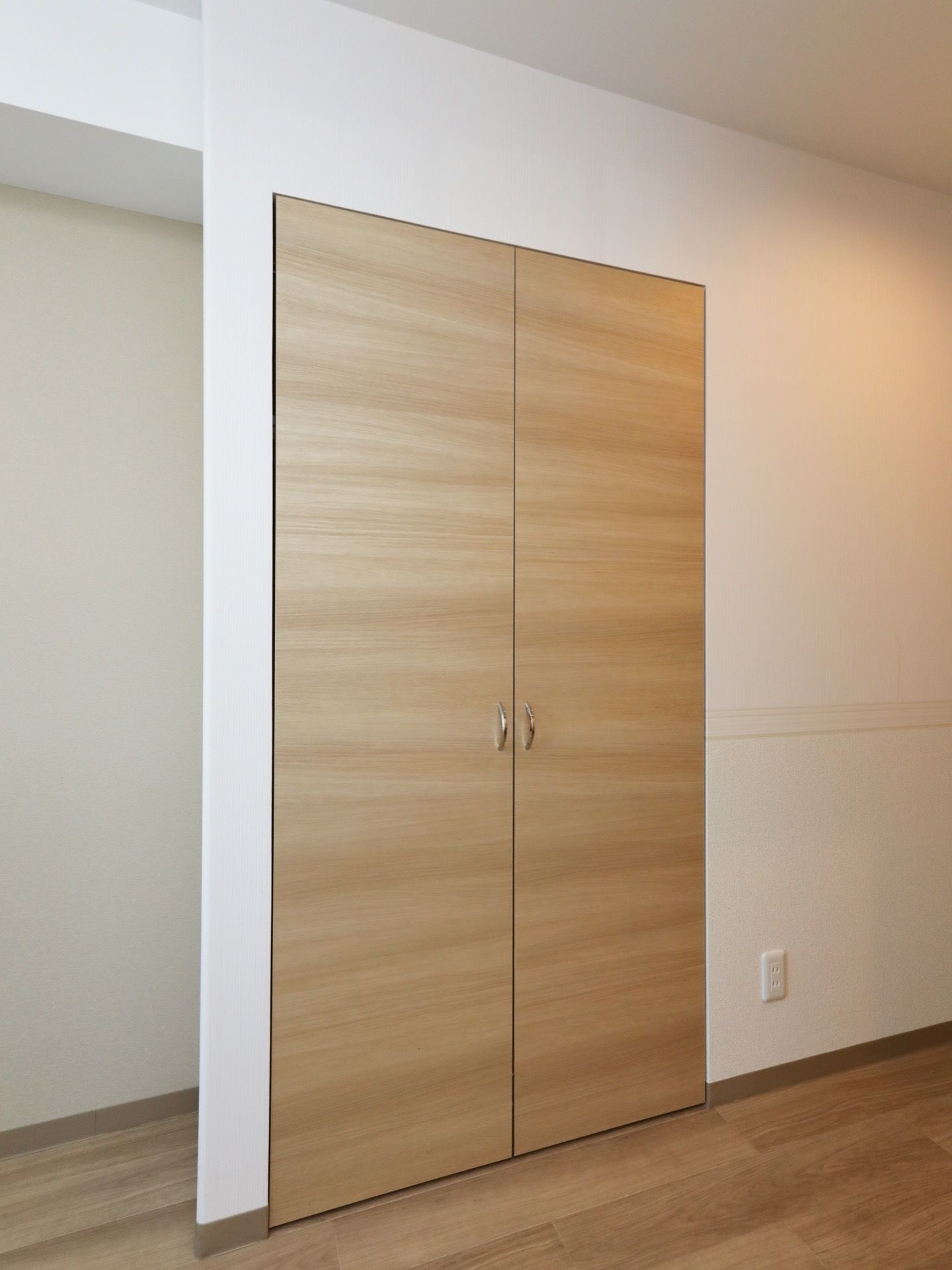 建具、床ともに木目調のデザインである。クローゼットが、居室に備え付けられている。両開き戸タイプである。