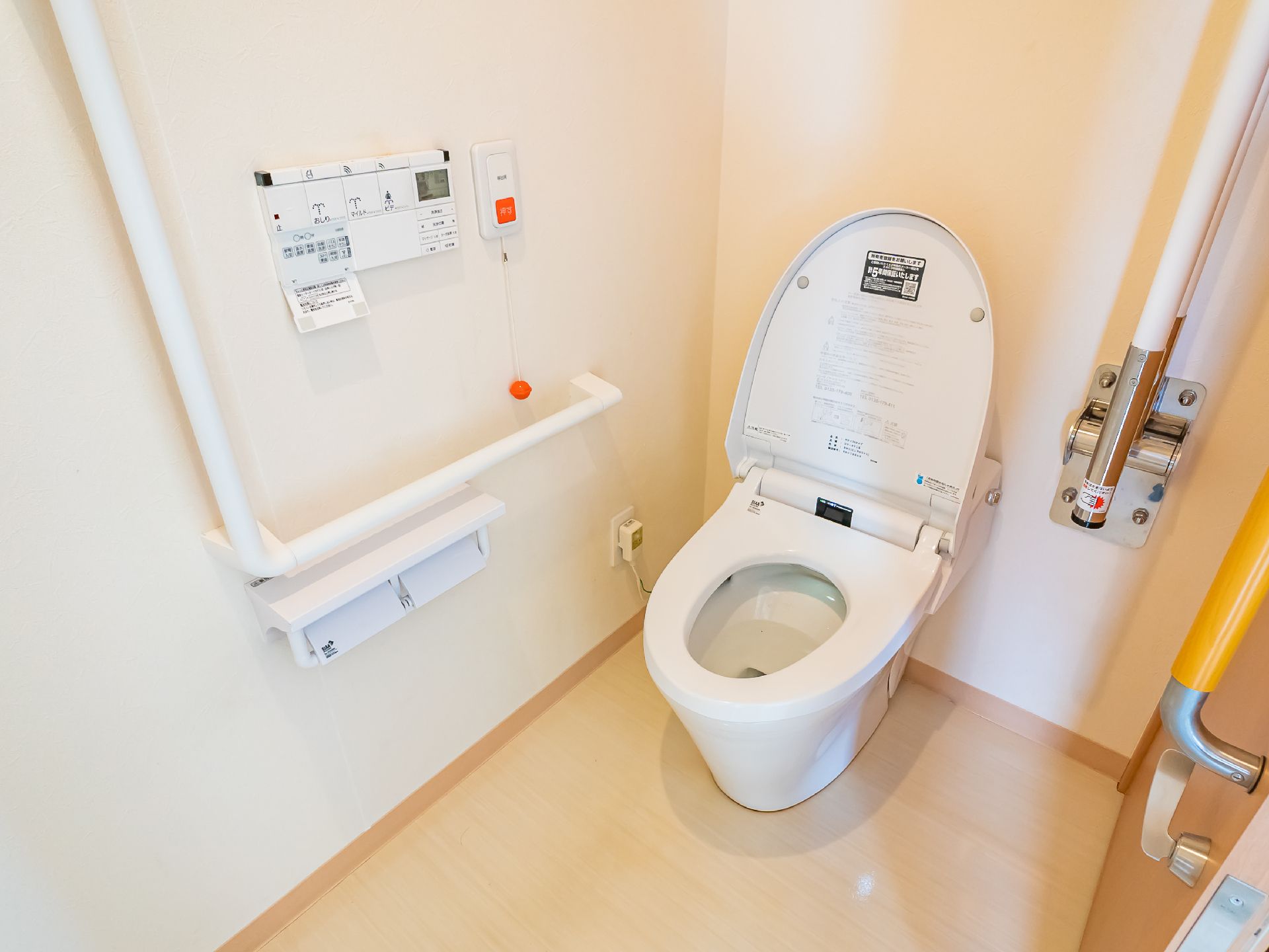高齢者でも楽に座ることが可能な、手すりのついたトイレ
