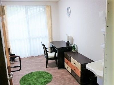 大きな窓があり明るい雰囲気。居室には、ベッドや収納家具だけでなく洗面所もついている。
