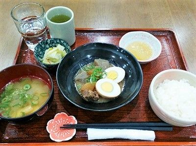 白いご飯にみそ汁、小鉢などが並んだトレー。煮込み料理がメイン。