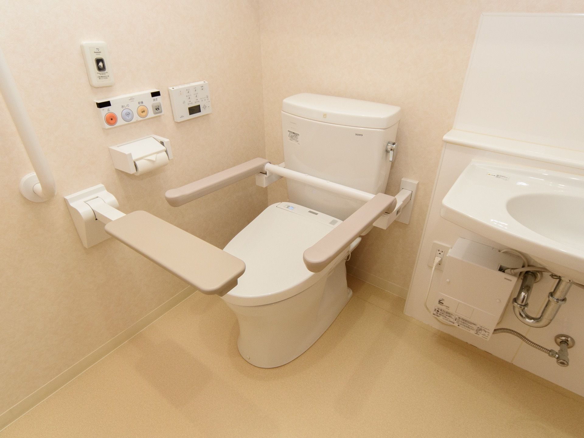 トイレは広々と造られていて、洗面台も設置されている。壁付けされた操作ボタンを押すだけで、簡単に利用できる。