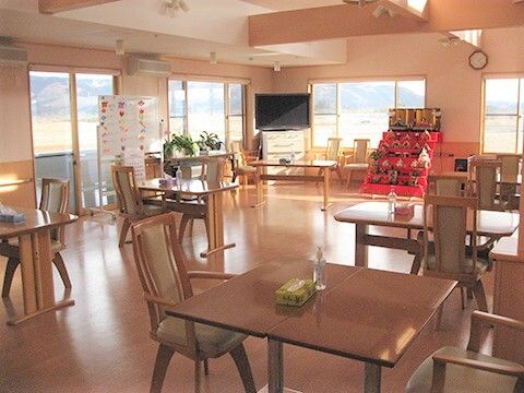 ひなかざりがある施設内のリビング。間をあけてイスとテーブルが配置されている様子